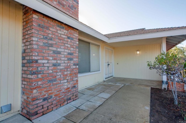 view of exterior entry with a patio area