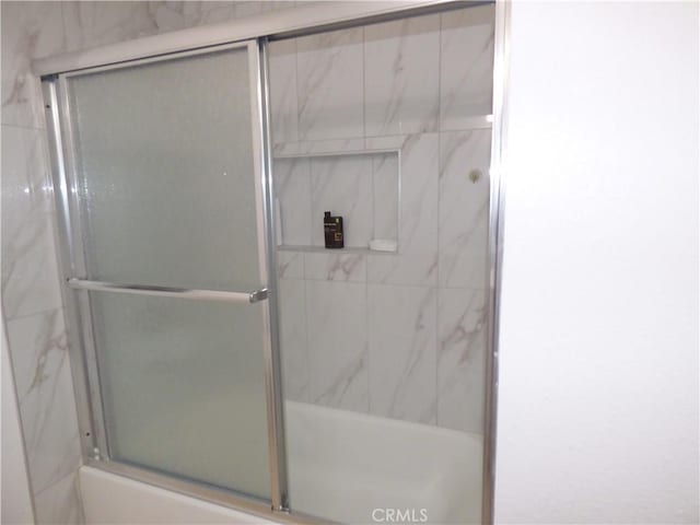 bathroom featuring bath / shower combo with glass door