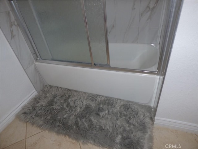 bathroom featuring combined bath / shower with glass door