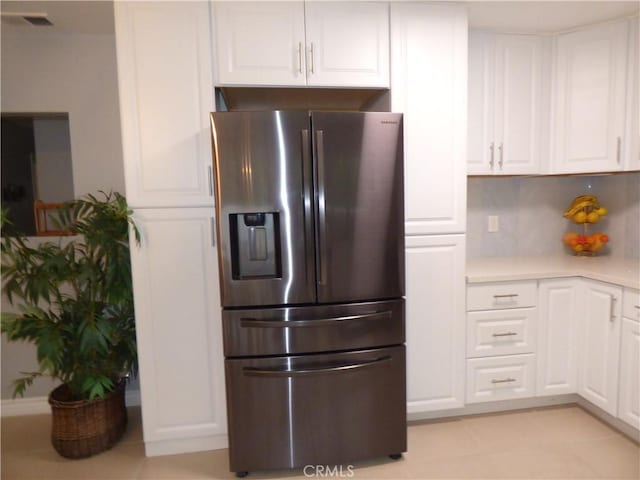 kitchen with stainless steel fridge and white cabinets