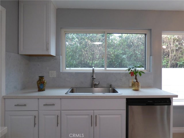 kitchen featuring white cabinetry, sink, stainless steel dishwasher, and backsplash