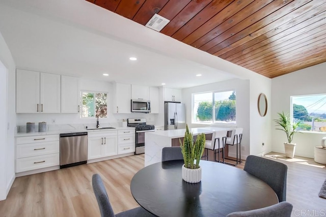 dining space featuring light hardwood / wood-style flooring, sink, and a wealth of natural light