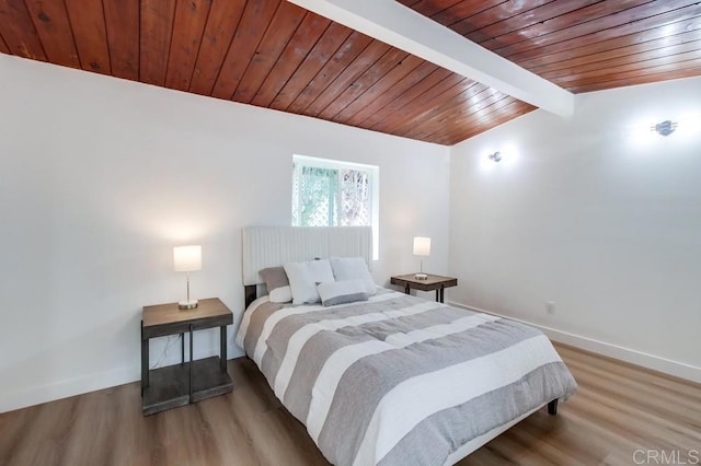 bedroom with hardwood / wood-style flooring, lofted ceiling with beams, and wooden ceiling