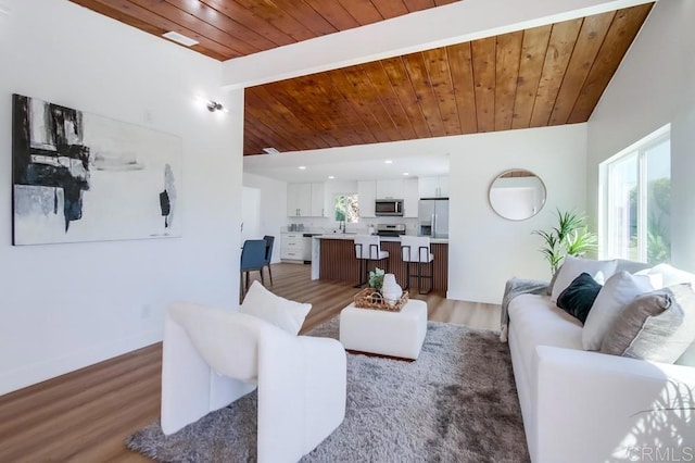 living room featuring vaulted ceiling, dark hardwood / wood-style floors, sink, and wooden ceiling