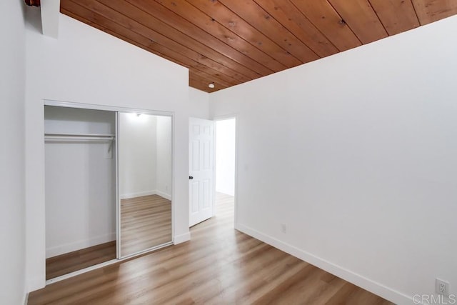 unfurnished bedroom with wood ceiling, a closet, and hardwood / wood-style flooring