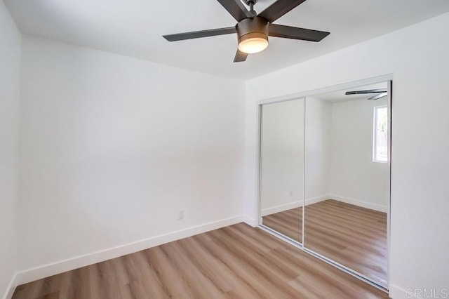 unfurnished bedroom with light hardwood / wood-style floors, a closet, and ceiling fan