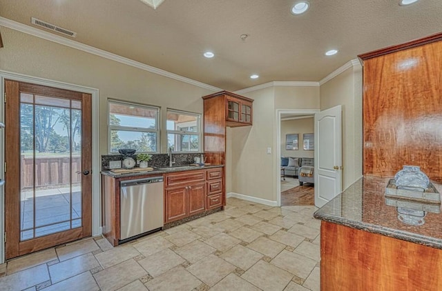 kitchen with sink, dishwasher, backsplash, ornamental molding, and dark stone counters