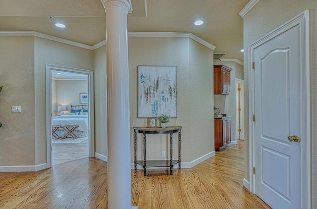 corridor featuring ornate columns, crown molding, and light hardwood / wood-style flooring