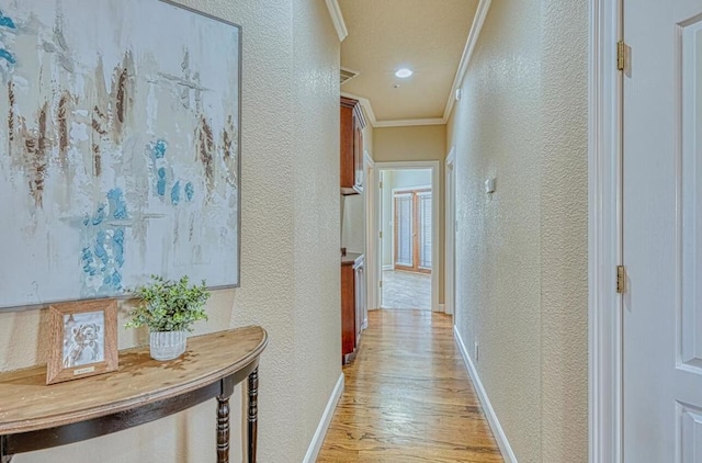 corridor with crown molding and light hardwood / wood-style flooring