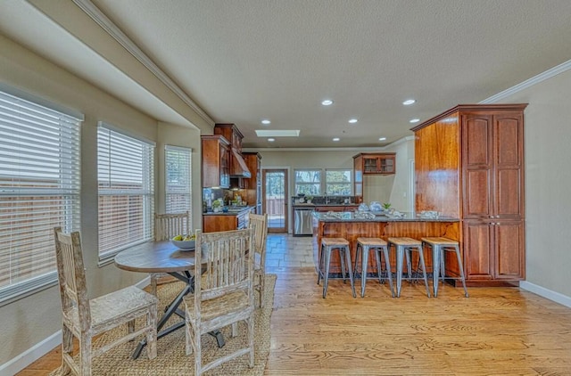 dining area with crown molding, light hardwood / wood-style floors, and a textured ceiling