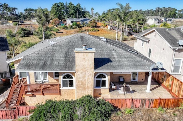 rear view of house with a wooden deck and a patio area