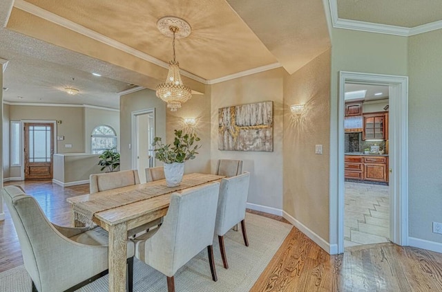 dining room featuring ornamental molding, a chandelier, and light hardwood / wood-style floors