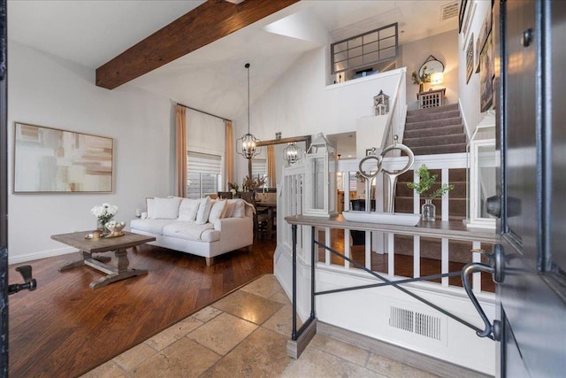 living room with high vaulted ceiling, a notable chandelier, and beam ceiling