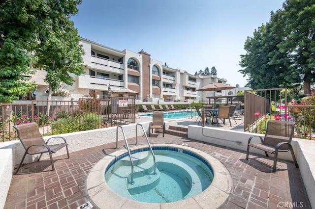 view of pool featuring a community hot tub and a patio area