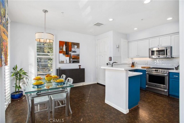 kitchen with blue cabinetry, white cabinetry, tasteful backsplash, hanging light fixtures, and stainless steel appliances