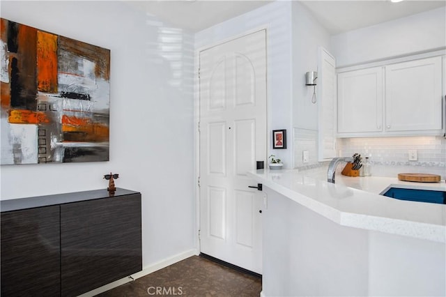 kitchen with tasteful backsplash and white cabinets