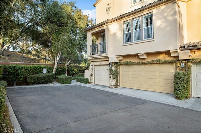 view of property exterior with a garage and a balcony