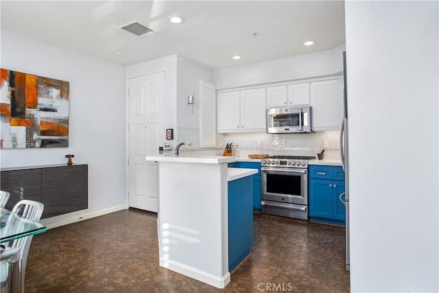 kitchen with blue cabinetry, appliances with stainless steel finishes, backsplash, white cabinets, and kitchen peninsula