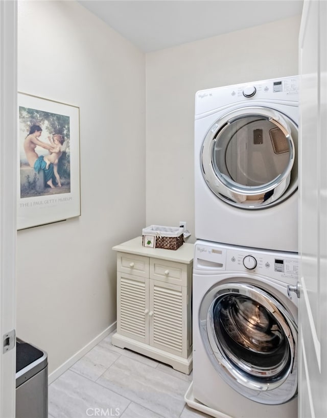 laundry room featuring cabinets and stacked washer and clothes dryer