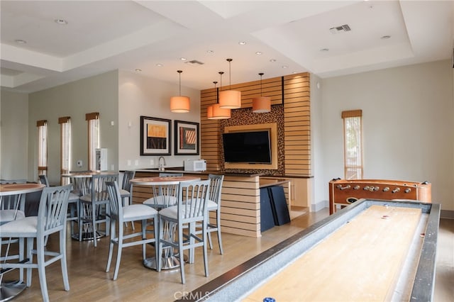 rec room featuring sink, a raised ceiling, and hardwood / wood-style floors