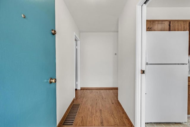 corridor with light hardwood / wood-style floors