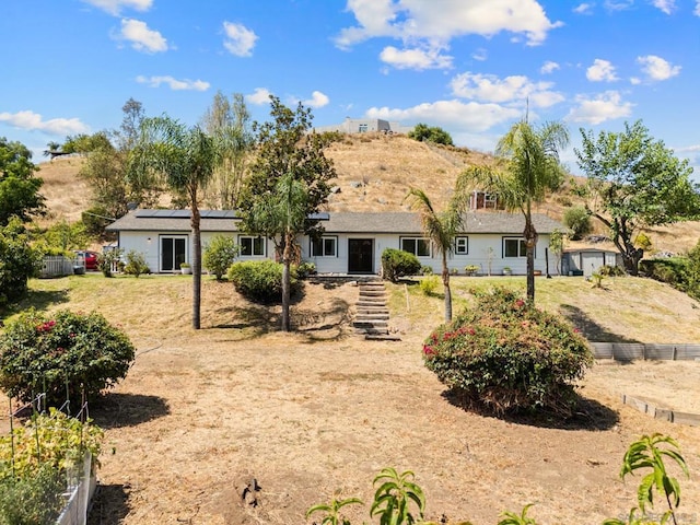 rear view of property featuring solar panels