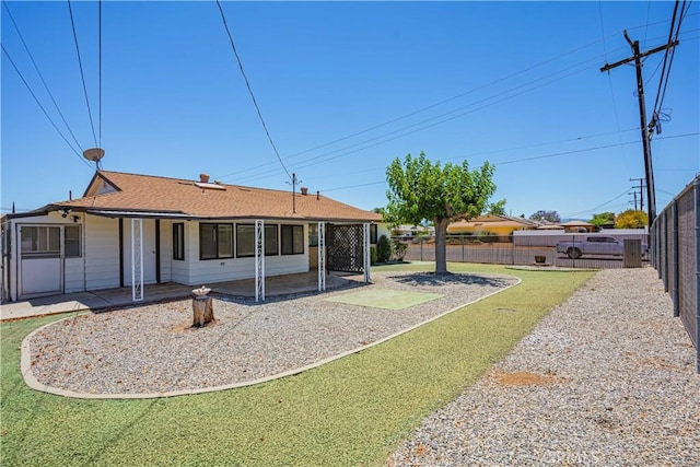 rear view of house featuring a yard and a patio area