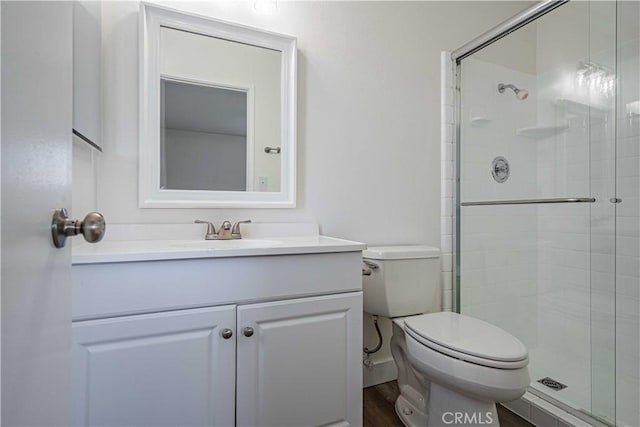 bathroom featuring vanity, a shower with shower door, wood-type flooring, and toilet