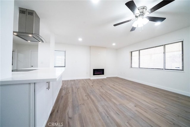 unfurnished living room with ceiling fan and light wood-type flooring