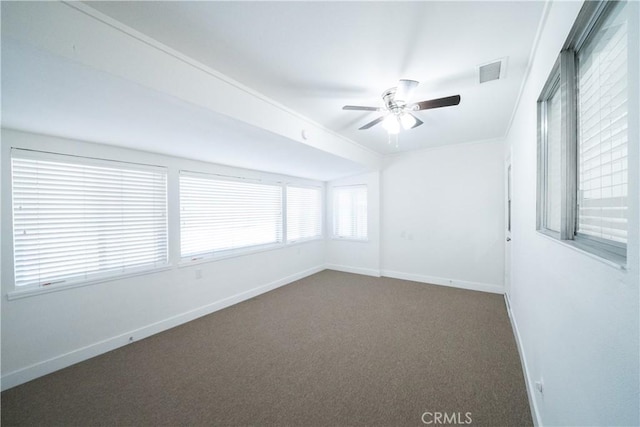 spare room with ceiling fan and dark colored carpet