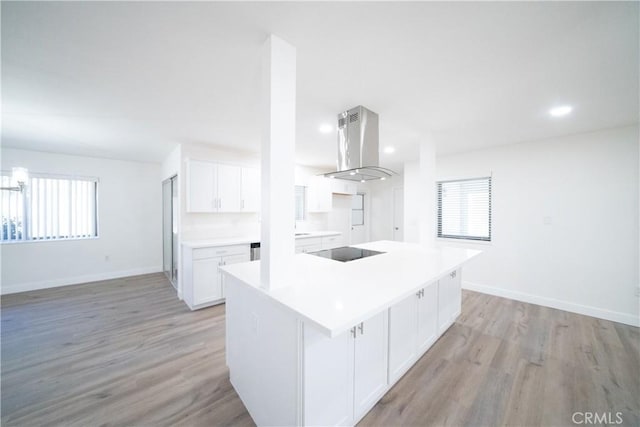 kitchen featuring light hardwood / wood-style flooring, island exhaust hood, white cabinets, a kitchen island, and black electric cooktop