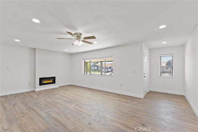 29460 Thornhill, Menifee, CA 92586 - unfurnished living room with light wood finished floors, ceiling fan, a glass covered fireplace, and recessed lighting
