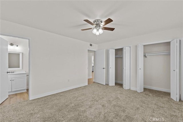 29460 Thornhill, Menifee, CA 92586 - unfurnished bedroom featuring baseboards, two closets, connected bathroom, ceiling fan, and light colored carpet
