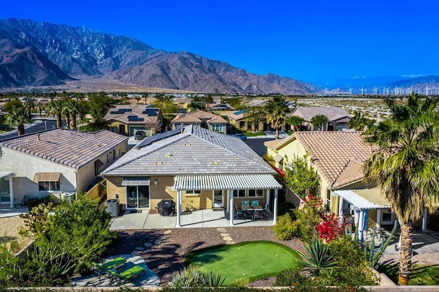 exterior space featuring a patio, a mountain view, and solar panels