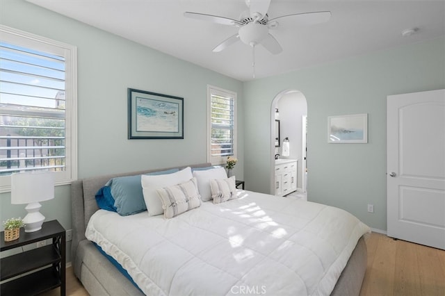 bedroom with ceiling fan, connected bathroom, and light hardwood / wood-style floors