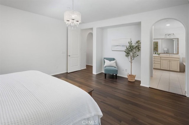 bedroom featuring a notable chandelier, dark hardwood / wood-style floors, and ensuite bathroom