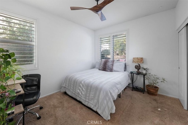 carpeted bedroom with ceiling fan and a closet