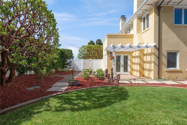 view of yard featuring a pergola and french doors