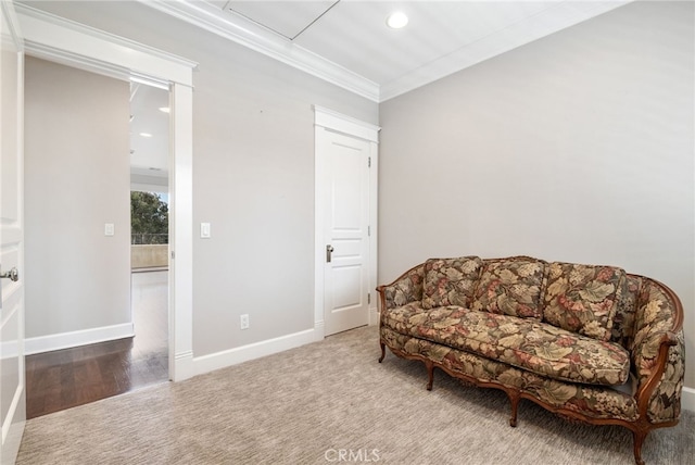 living area with ornamental molding and carpet