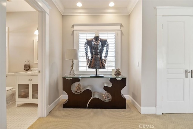 sitting room with ornamental molding and light carpet