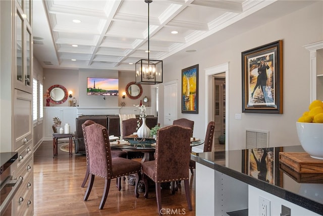 dining room featuring ornamental molding, coffered ceiling, dark hardwood / wood-style flooring, and beam ceiling