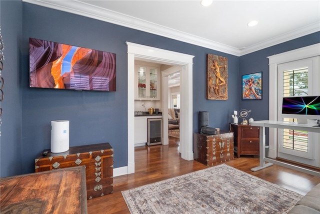 interior space featuring ornamental molding, beverage cooler, dark hardwood / wood-style flooring, and bar area