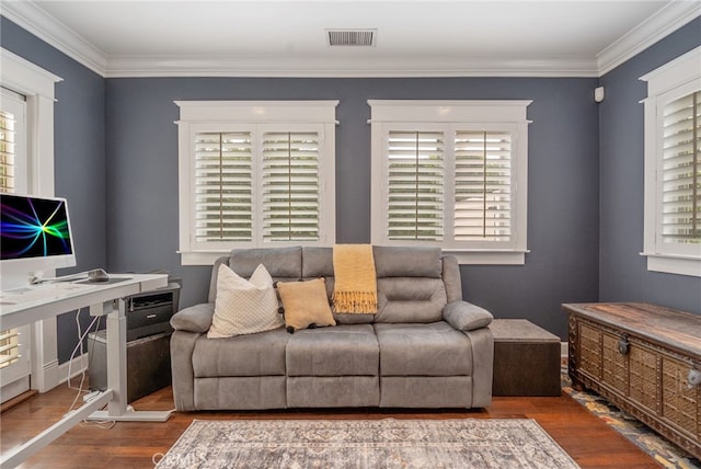 living room with crown molding, a healthy amount of sunlight, and hardwood / wood-style floors