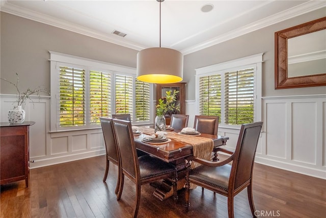 dining space featuring dark wood-type flooring, a wealth of natural light, and ornamental molding