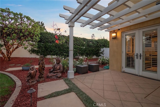 patio terrace at dusk featuring french doors and a pergola