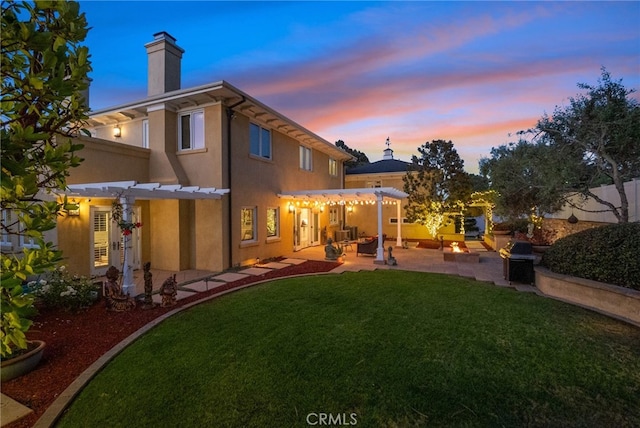 back house at dusk with a yard, a patio area, and a pergola