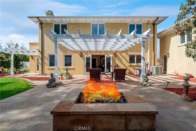 rear view of house with central AC, an outdoor fire pit, a pergola, and a patio