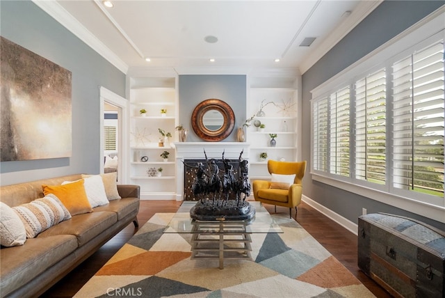 living room featuring dark wood-type flooring, crown molding, and built in features