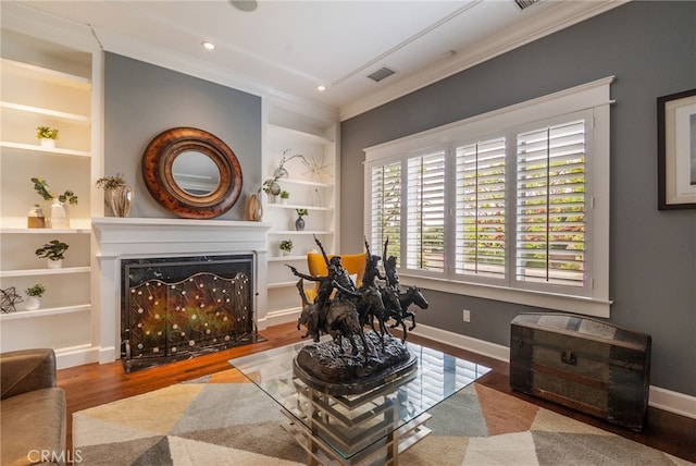 sitting room with hardwood / wood-style flooring, crown molding, and built in features