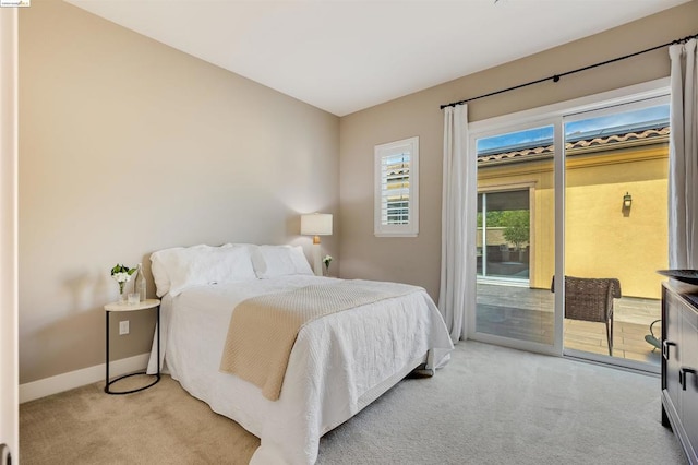 bedroom with access to exterior and light colored carpet